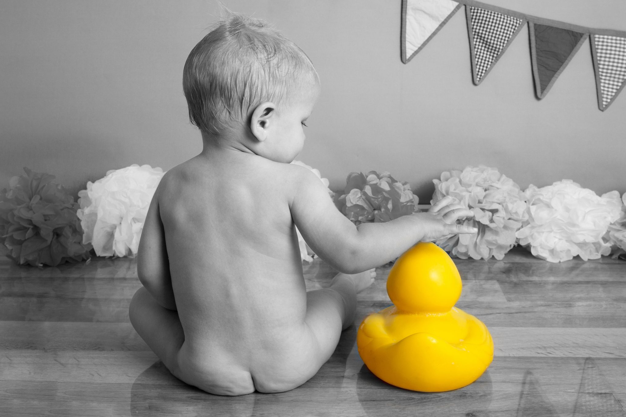 color splash image of baby bottom with yellow duck at cakesmash photoshoot in east grinstead