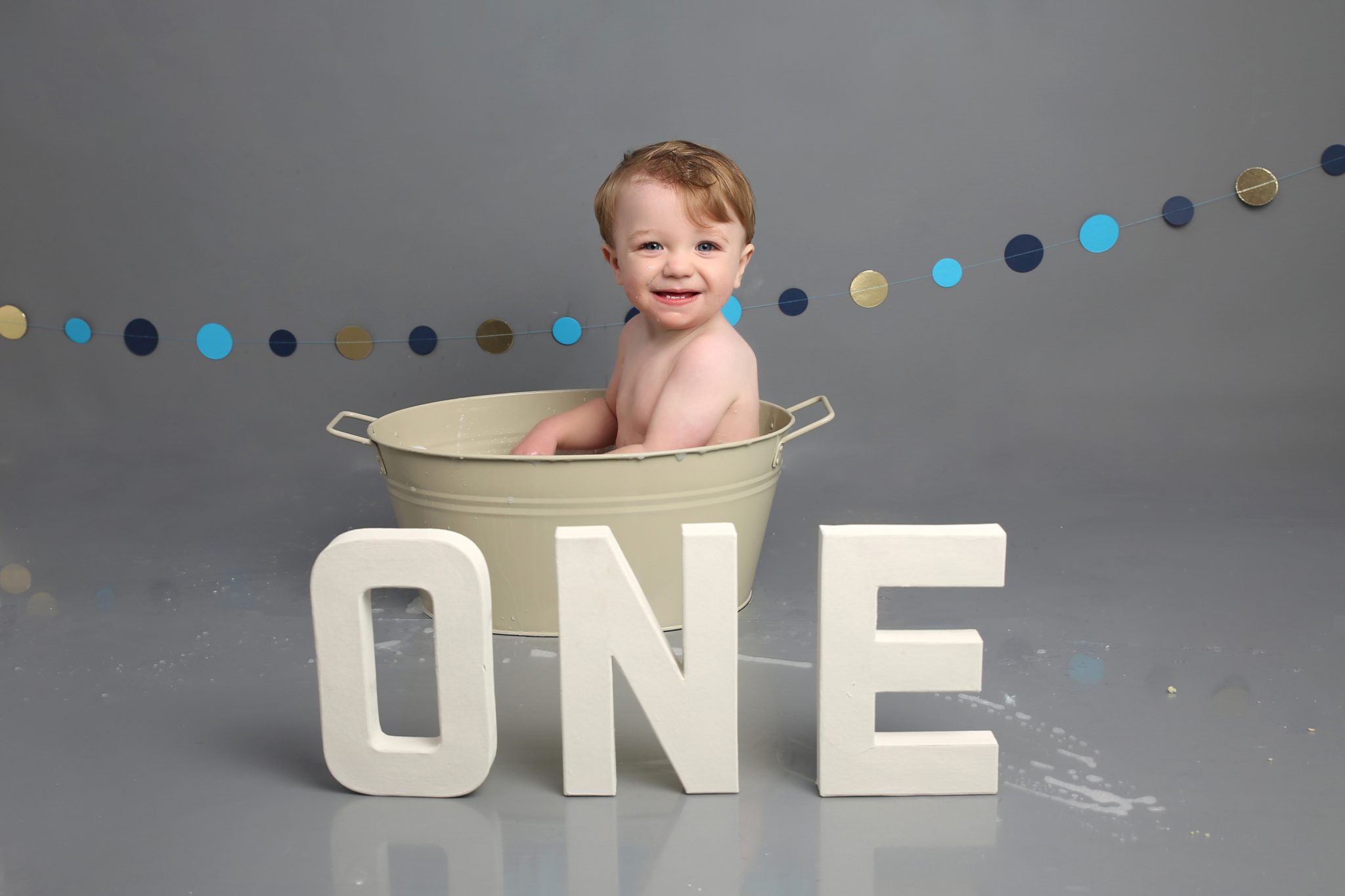 little boy sitting in bath tub with ONE prop at cakesmash photoshoot in east grinstead