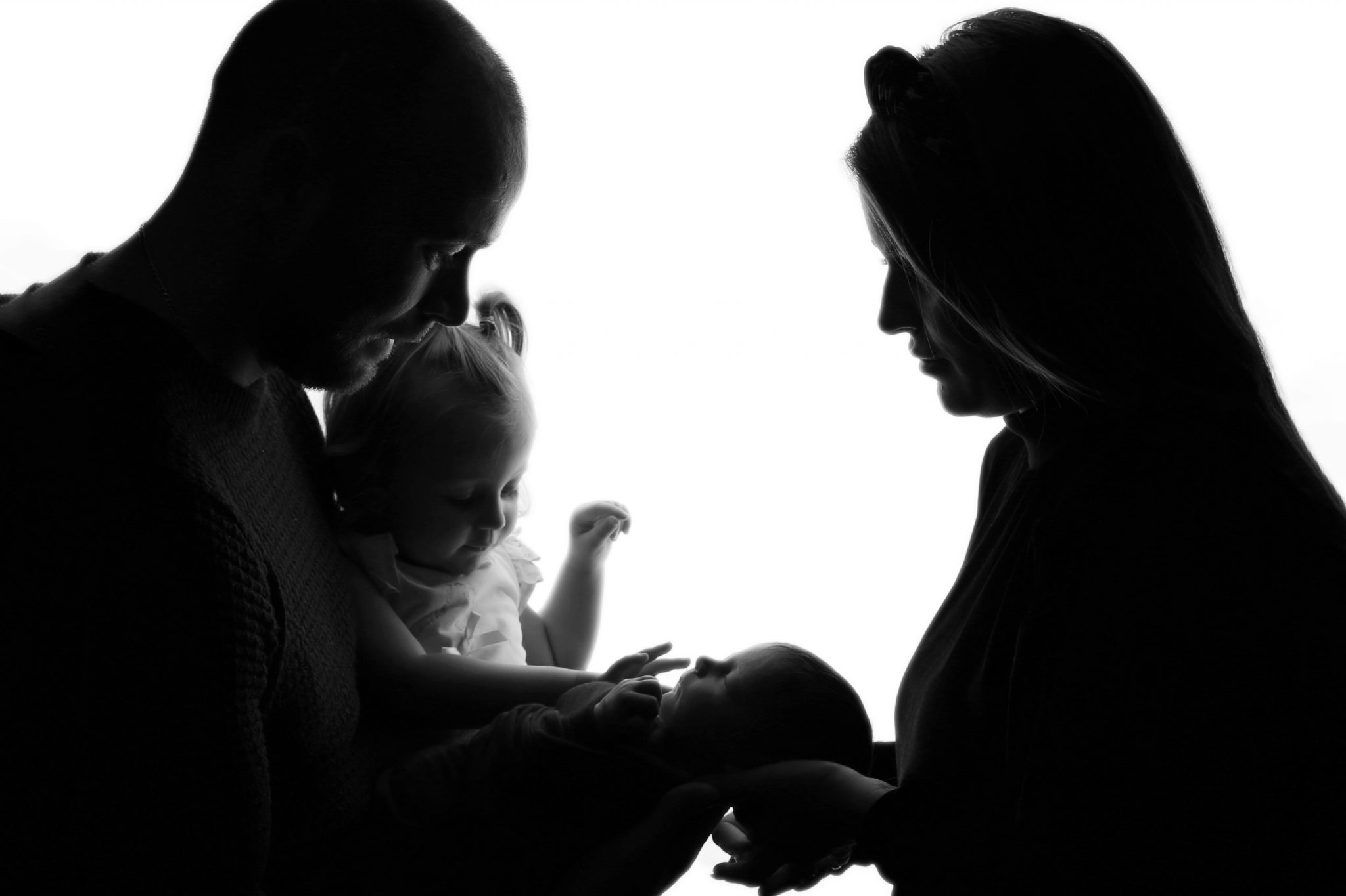 family of 4 silhouette image with newborn baby and sister on photoshoot in west sussex